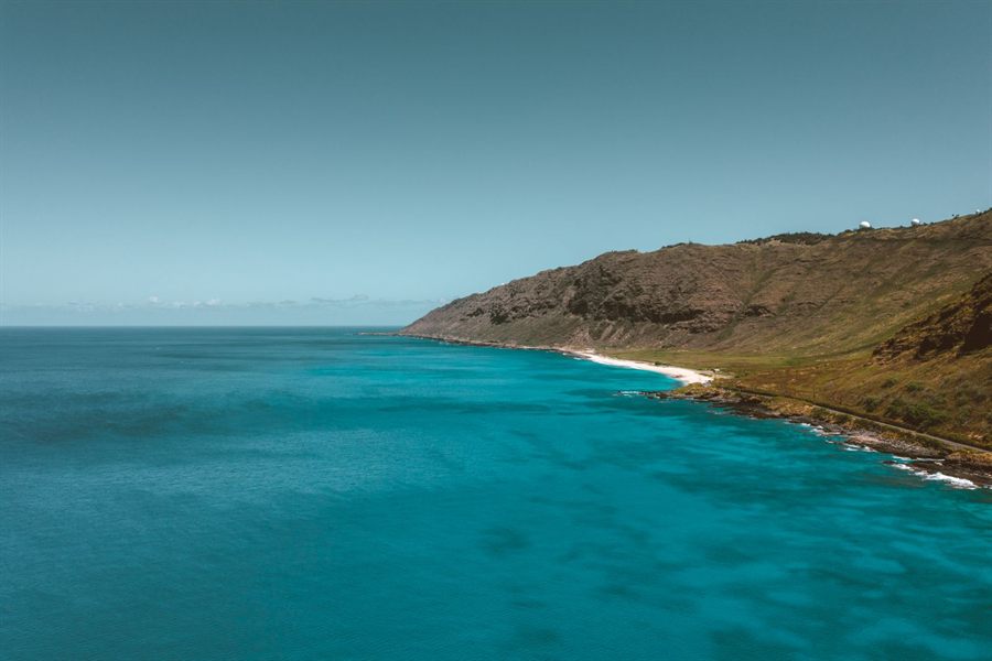 Rugged green coastline of Oahu, Hawaii, above clear blue water