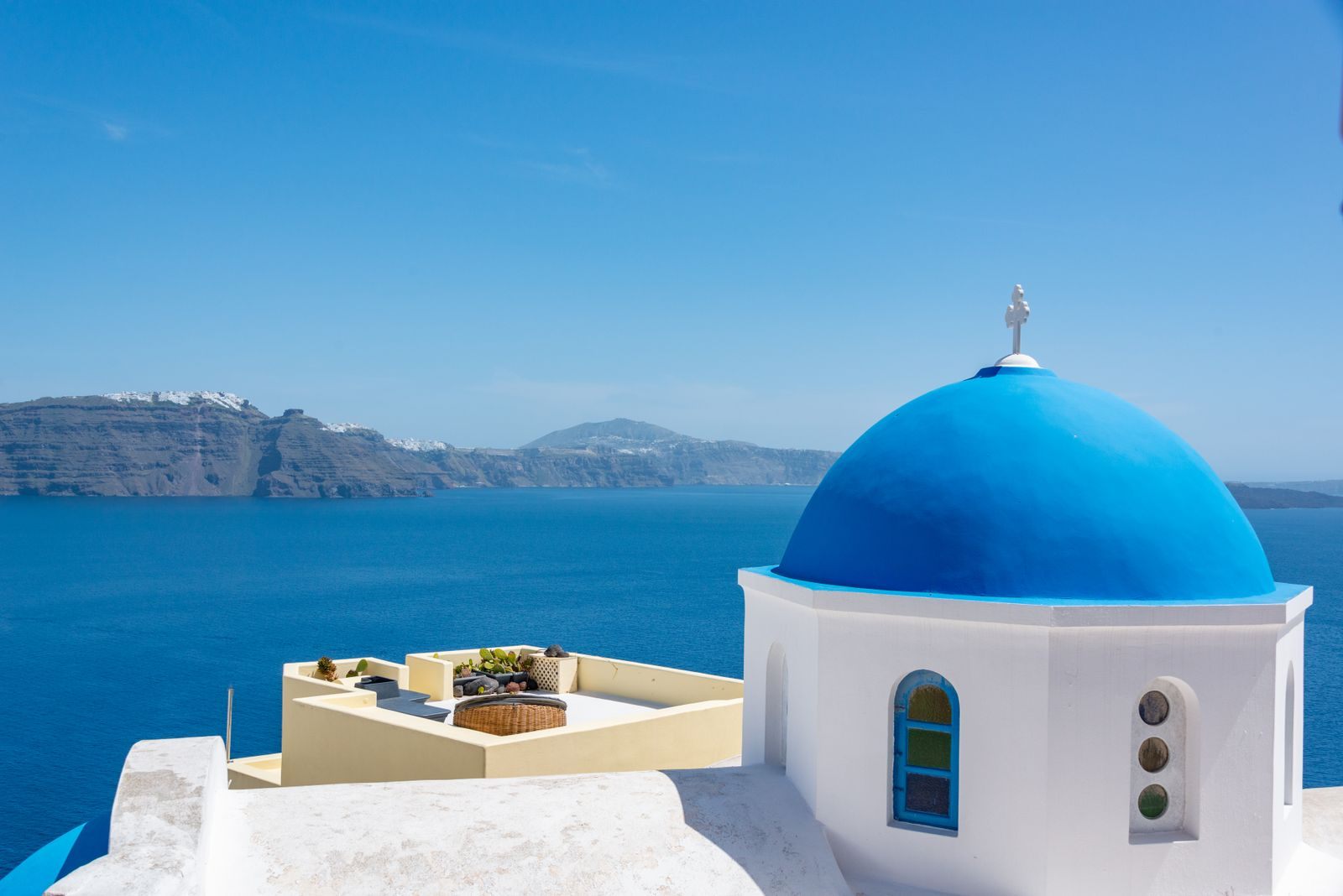 Blue-domed chapel above the Aegean Sea in Santorini, Greece