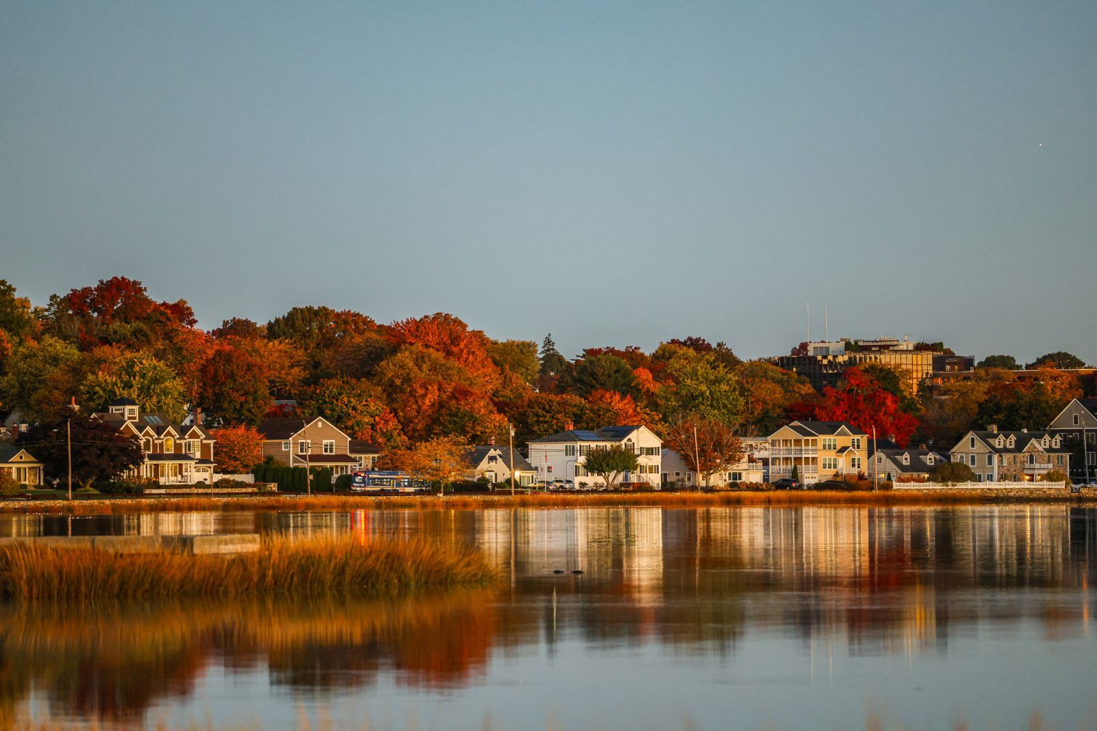 Autumn trees and a calm New England shoreline in Connecticut, one answer to where to cruise in October